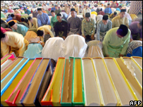 Malaysian Muslims pray behind of the Koran during a special morning prayer at the National Mosque in Kuala Lumpur