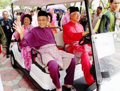 Top driver and VIP passengers: Dr Mahathir is committed to helping Najib and Umno win the general election. They are seen here with their spouses in a golf buggy during the last Hari Raya open house at Seri Perdana.